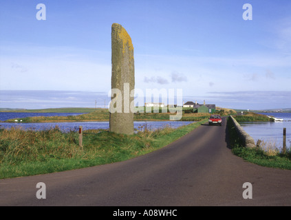 dh Watch stone STENNESS ORKNEY Standing stone car on road between Loch of Harray and Loch of Stenness travel driving scotland Stock Photo