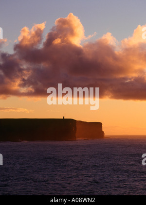 dh Birsay Bay BIRSAY ORKNEY Marwick Head cliffs and Kitchener Memorial with sunset storm clouds Stock Photo
