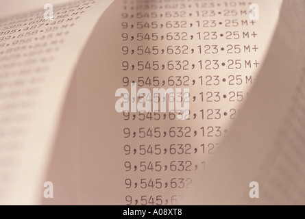 Adding machine tape abstract spiraling endless rows of large numbers. Stock Photo