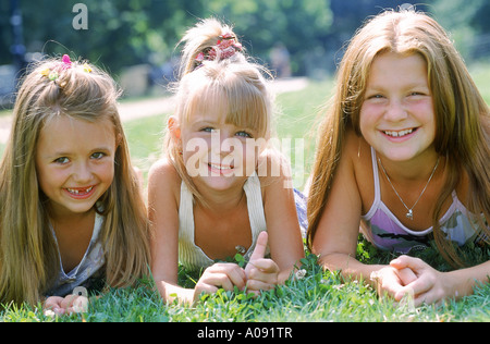 Portrait of three girls lying on grass Stock Photo