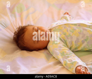 A 15 month old baby boy asleep on a bed in Hong Kong Stock Photo