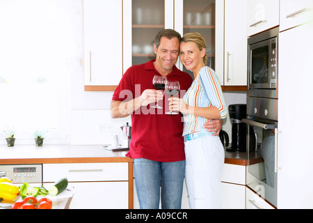 Verliebtes Paar trinkt Rotwein in der Kueche, couple drinking red wine in kitchen Stock Photo