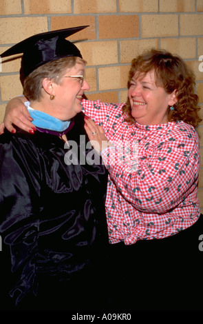 Friends age 56 celebrating masters degree graduation at St Thomas University St Paul Minnesota USA Stock Photo