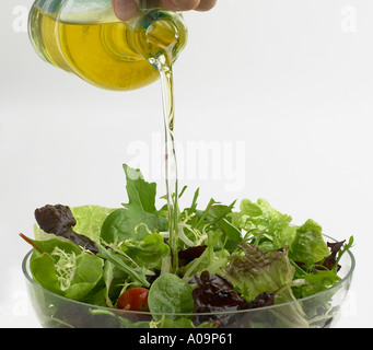 pouring olive oil on to a salad Stock Photo