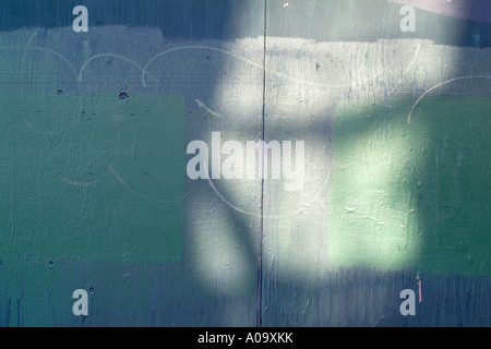 Light on a painted wooden wall forms an abstract pattern background with hues of green Stock Photo