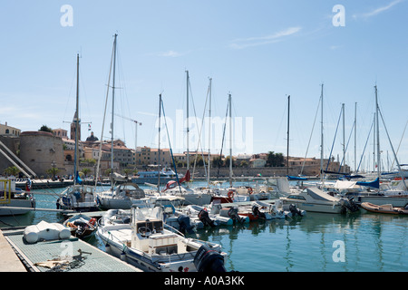 Boats in the harbour with the walls of  the old town behind, Alghero, Sardinia, Italy Stock Photo