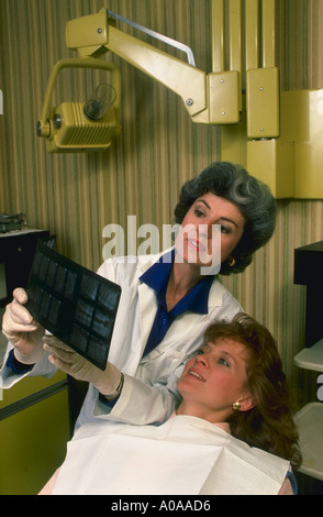 Dentist discusses x rays with patient Also have male in the same situation Stock Photo