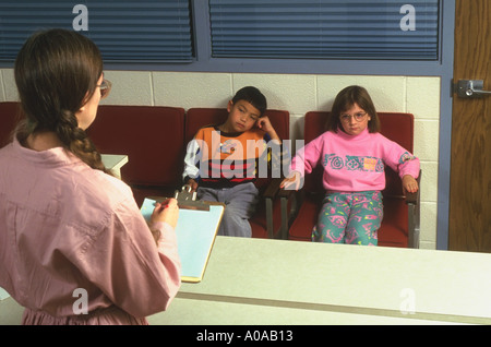 Two students sitting in office with principal model released Stock Photo