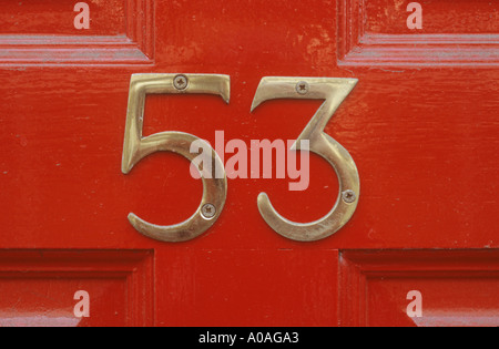 Brass number 53 on red painted wooden door Stock Photo