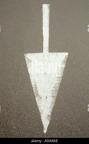 White painted arrow on road directing traffic Stock Photo