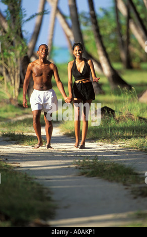 CARIBBEAN TRINIDAD TOBAGO Couple walking smiling and holding hands Pigeon Point Beach Tobago Stock Photo