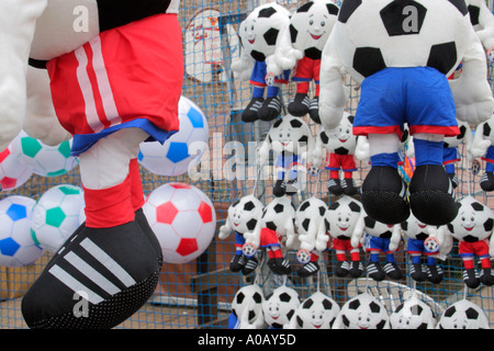 Inflatable footballs and soft toys in football strips Prizes at fairground stall Stock Photo