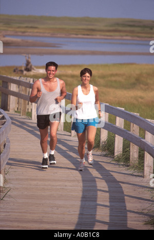 Young couple running on walkway or boardwalk in New Brunswick Canada Stock Photo