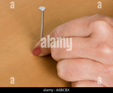 Woman ready to hammer a nail Stock Photo
