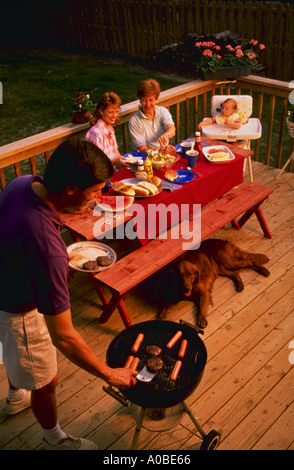 Three generations of family having cook out on back porch Stock Photo