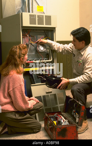 Serviceman talks to housewife about her furnace released CF39951 Stock Photo
