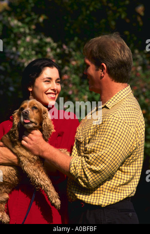 Young couple walking dog in the park Stock Photo