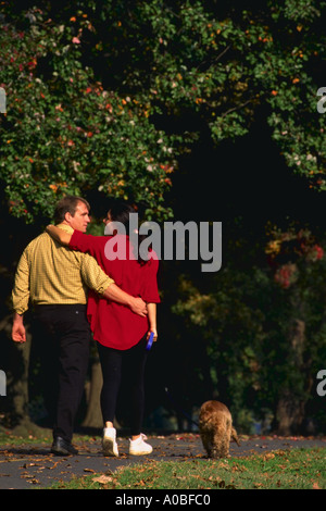 Young couple walking dog in the park Stock Photo