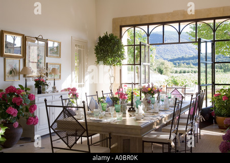 Dining room table set in room with open double doors Stock Photo