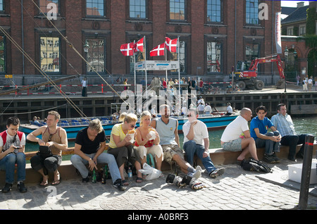 People relaxing on quayside, Nyhavn, Copenhagen, Denmark Stock Photo
