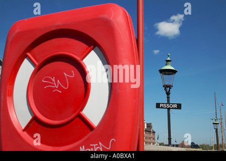 Red lifebelt box and pissoir public toilet sign, Nyhavn, Copenhagen, Denmark Stock Photo