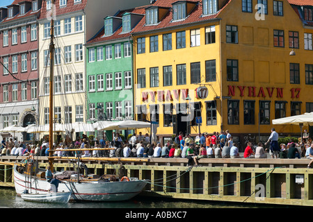 Moored sailboat, Nyhavn 17 cafe with crowded quayside, Nyhavn, Copenhagen, Denmark Stock Photo