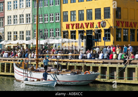 Moored sailboat, Nyhavn 17 cafe with crowded quayside, Nyhavn, Copenhagen, Denmark Stock Photo