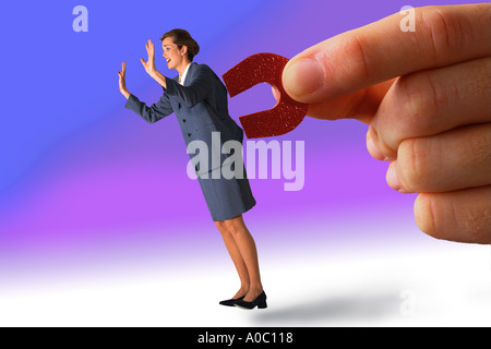 Businesswoman pulled by magnet Stock Photo