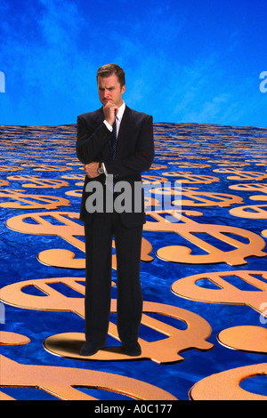 Businessman standing on money thinking Stock Photo