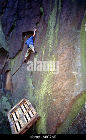 Johnny Dawes climbs above a wooden pallet in Millstone quarry nr Sheffield South Yorkshire England Stock Photo