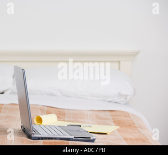 Still life of laptop computer on bed Stock Photo