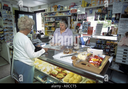 Paying for the weekly newspapers in a village shop and post office in North Devon England Stock Photo