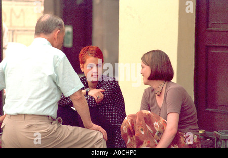 Friends age 25 sitting talking on steps. Poznan Poland Stock Photo