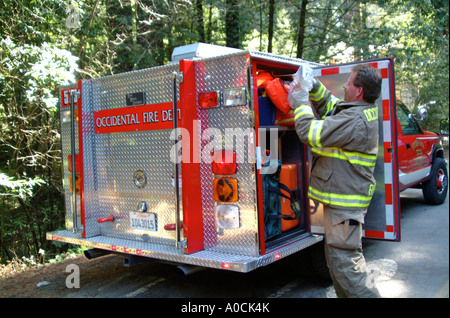 A firefighter puts back supplies into the rescue squad after a vehicle accident in Occidental California Stock Photo