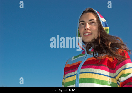 Young woman wearing hooded sweater standing outdoors Stock Photo