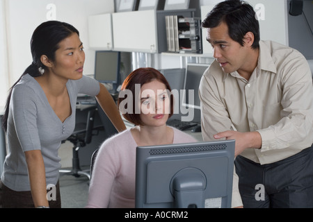 Office workers conferring at computer Stock Photo