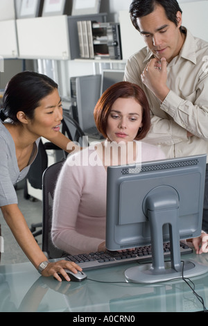 Office workers conferring at computer Stock Photo