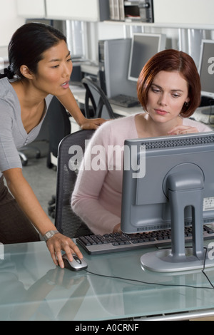 Office workers conferring at computer Stock Photo