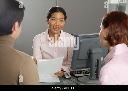 Businesswoman talking to couple Stock Photo