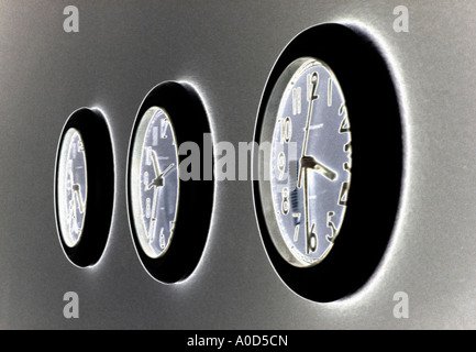three office wall clocks  set at different times Stock Photo