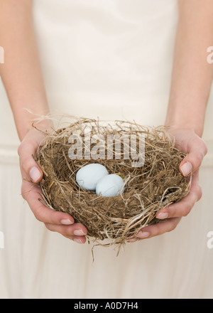 Female holding nest with eggs Stock Photo