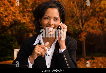 African American businesswoman doing business outdoors and talking on cell phone Stock Photo