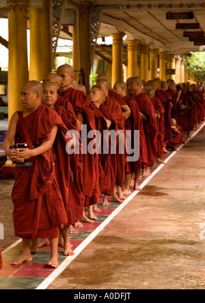 Stock photograph of  Buddhist monks with their begging bowls awaiting meal time at Kha Khat Wain Kyaung at Bago in Myanmar 2006 Stock Photo