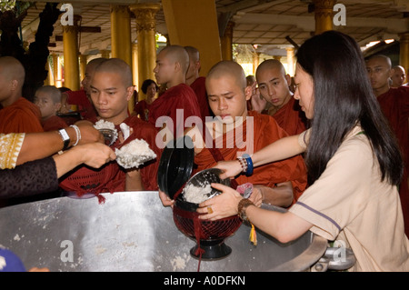 Stock photograph of Buddhist monks being served at meal time at Kha Khat Wain Kyaung at Bago in Myanmar 2006 Stock Photo