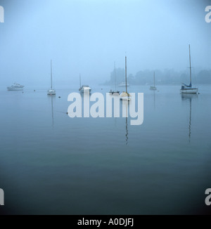 Boats moored in early morning mist, Oulton Broad, Suffolk, England UK Stock Photo
