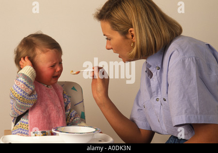 toddler refusing food offered on a spoon Stock Photo