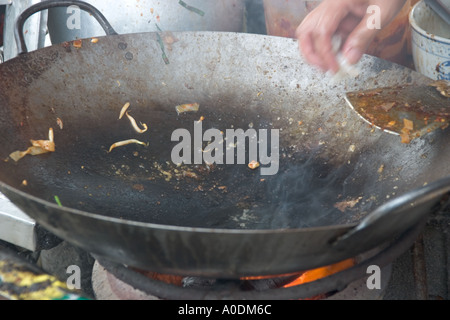 Roadside food hawker preparing fried rice noodles Char Kway Teow in Tanjung Bungah Penang Stock Photo