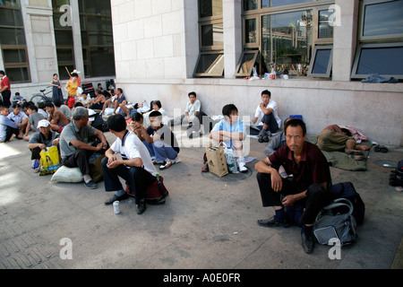 Chinese workers waiting for trains outside Beijing railway station. Stock Photo