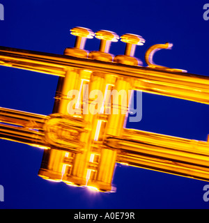abstract detail of golden trumpet keys on vibrant blue background with flash and tungsten motion blur, matching shot of guitar. Stock Photo
