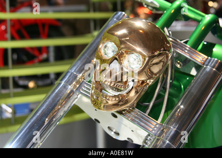 Gold coloured metallic skull with eyes as headlights on a special show motorcycle. Stock Photo